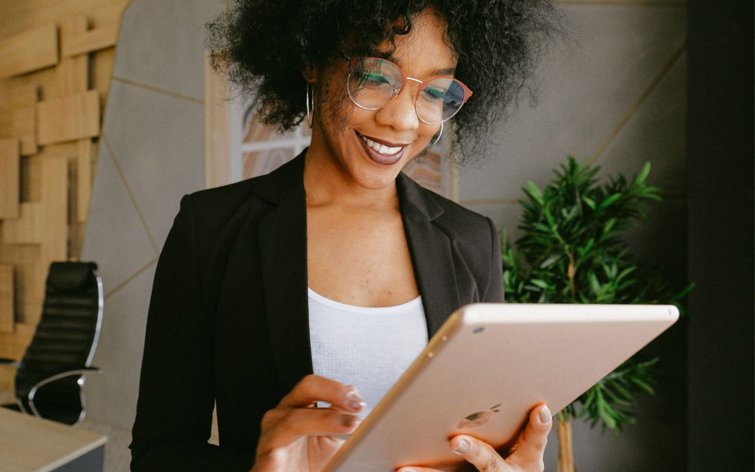 Woman wearing glasses and holding a rose gold iPad Pro