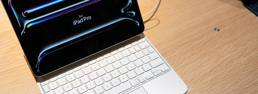 an ipad with keyboard sitting on top of a wooden desk